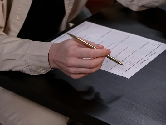 Men writing on paper with pen