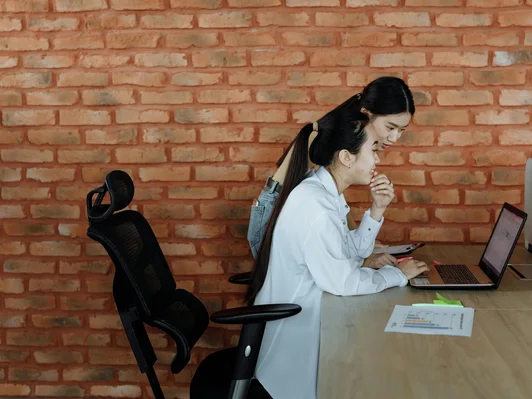 Two girls working on the desk in lab coat